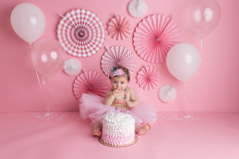A girly cake smash with pink and white props in a New Jersey