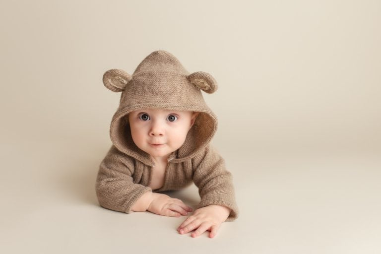 baby boy wearing cute teddy bear hoodie during a tummy time photo session