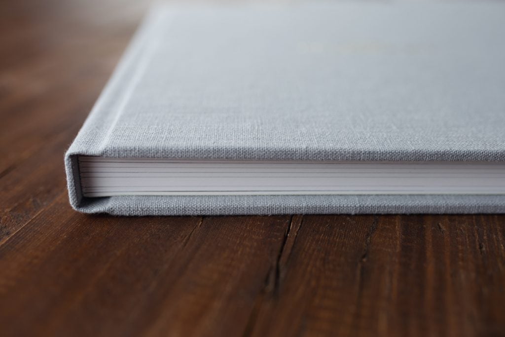 closeup of closed album resting on a tabletop, product offered by Yvonne Leon Photography.
