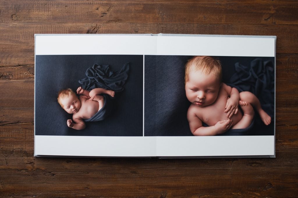 album page layout of newborn images in a rich dark blue color.