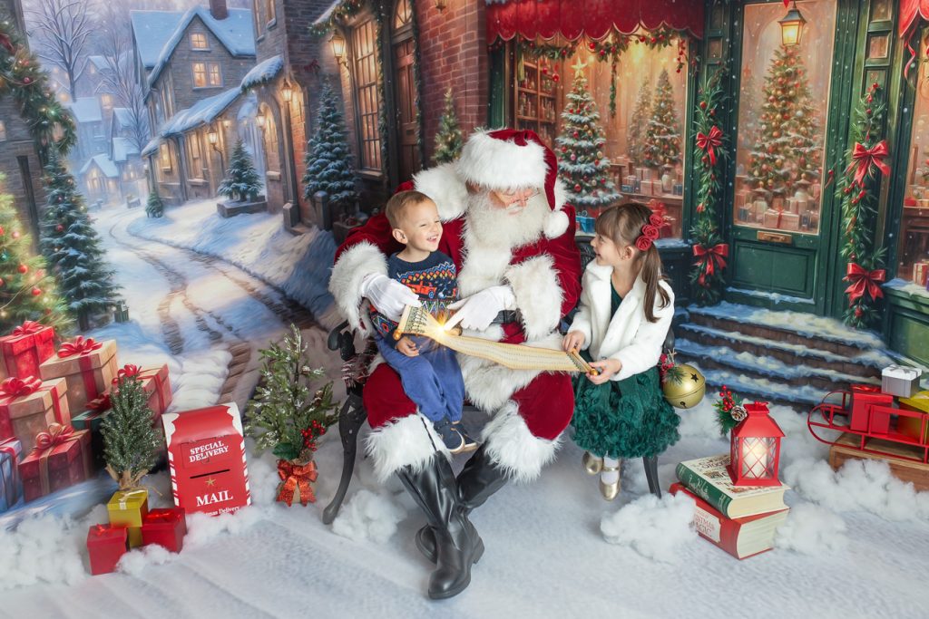 Santa sits on bench with two young kids, points to scroll with light burst at his finger; girl looks amazed, brother laughs.